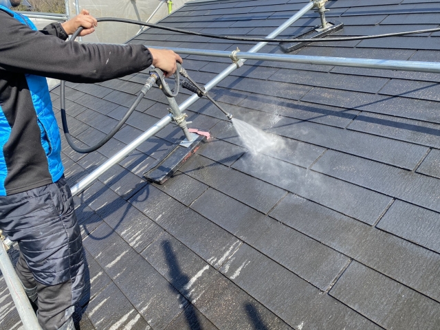 屋根の高圧洗浄をしている作業員