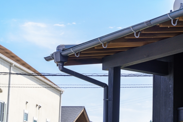 住宅の屋根に取り付けられた雨樋と青空