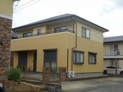 イエローの外壁の戸建て住宅